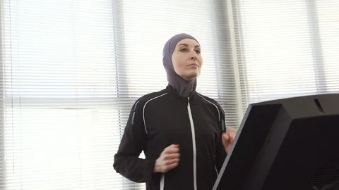 Athlete girl in hijab on a running simulator Video stock 87529341