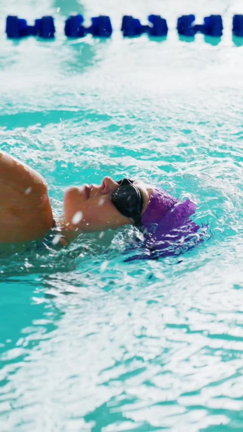 Athlete glides calmly on back through pool Stock Footage 346457635