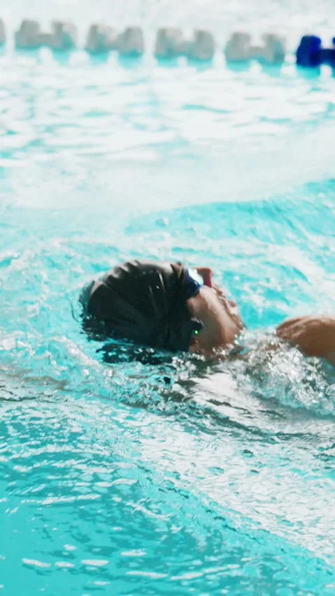 Athlete glides through bright blue water with powerful strokes Vídeos de archivo 346453727