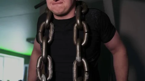 Athlete in gym doing exercises on parallel bars with chain around his neck Stock Footage 77995221