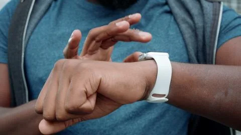 Athlete hands using smartwatch outdoors. Jogger checking results on smart watch Stock Photos