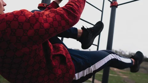 The athlete is hanging on the horizontal bar holding hands. Stretching. Close up Stock Footage 129354590