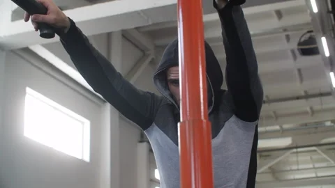 Athlete hanging from pull up bar catching breath Stock Footage 292047737