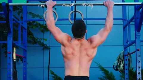 The athlete hangs on a crossbar at the street Stock Footage