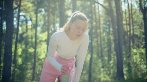 Athlete hydrates after walking through bright pine forest Stock Footage 346662827
