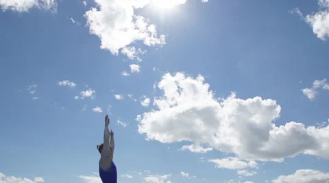 Athlete jumps on trampoline on background of clouds Stock Footage 57142260
