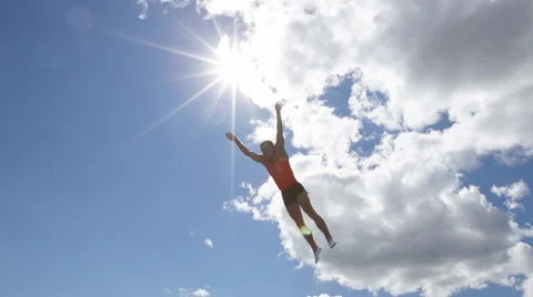 Athlete jumps on trampoline on background of clouds Vídeo Stock 57170677