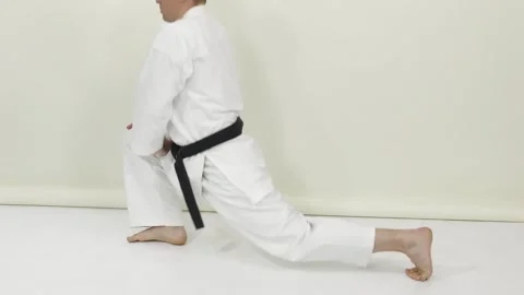 Athlete in karategi performs stretching exercises Stock Footage 246983874