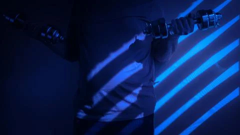 Athlete lifting dumbbells in dramatic blue lighting with shadows Stock Photos
