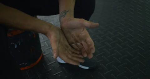 Athlete looking at their rough hands after a workout in a crossfit gym Vídeos de archivo 96955708