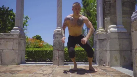 Athlete makes push-ups with movements among bricks and ancient columns Stock Footage 112697174