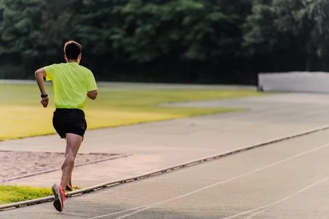 Athlete making big strides while running on the athletics track. Copy space Stock Photos