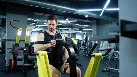 Athlete making exercise for back on row machine. Handsome athlete concentrated Video stock 284707181