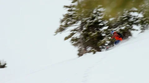 Athlete making turns while skiing through the snow covered mountain slopes Stock Footage 116785797
