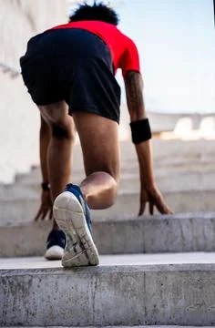 Athlete man in start position preparing to run outdoors. Stock Photos