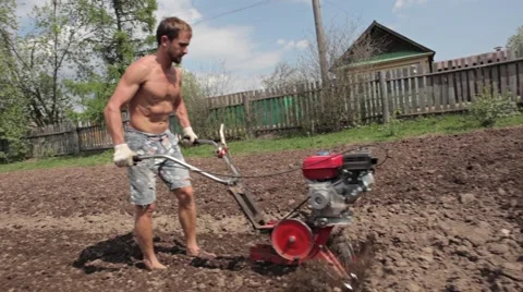 Athlete man is working in the field with ripper cultivator Stock Footage 56978119