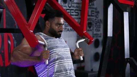 Athlete muscular bodybuilder doing  Machine Shoulder Press Exercise in gym Stock Footage 213288011