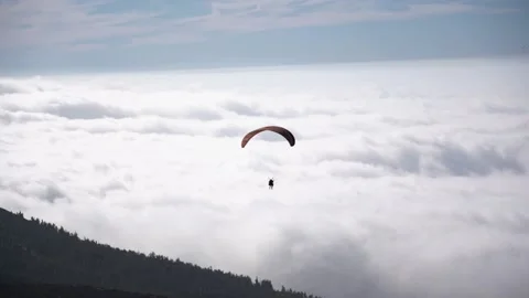 Athlete paragliding against the backdrop of a cloudy sky over the mountains  Video stock 170784520
