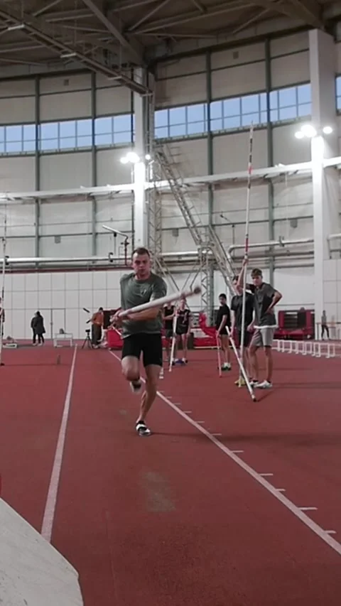 Athlete performing indoor pole vault jump training Stock Footage 330460377