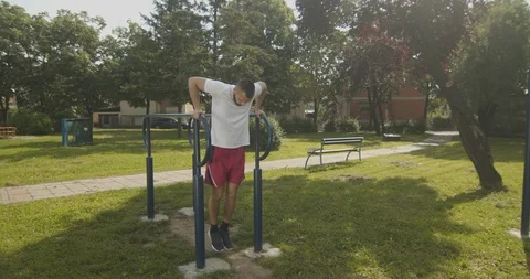 Athlete Performing Pull Up Exercise on Parallel In The Park, Slow Motion. Video stock 108743236