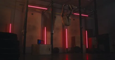 An athlete performs a difficult exercise on the horizontal bar in a modern gym Stock Footage 313358596