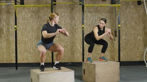 Athlete performs dynamic box jump in slow motion at gym for strength Video stock 321398324