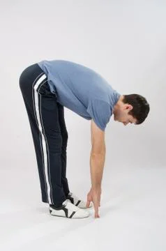 The athlete performs a forward bend Stock Photos
