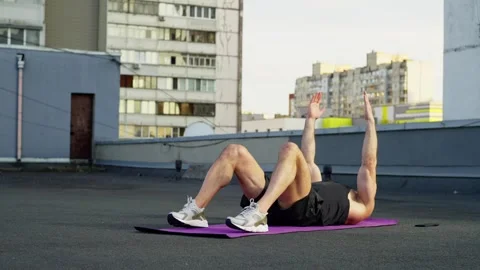 The athlete performs the press exercise lying on his back on the mat. Stock Footage 247457666