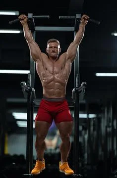 Athlete performs pull ups in gym during workout session for strength training Stock Photos