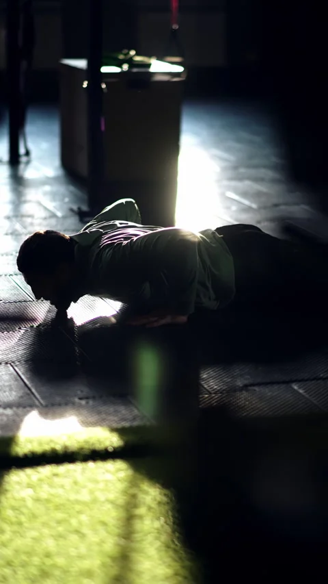 Athlete performs push-ups, takes a break, performs more push-ups, does squats Stock Footage 297529329