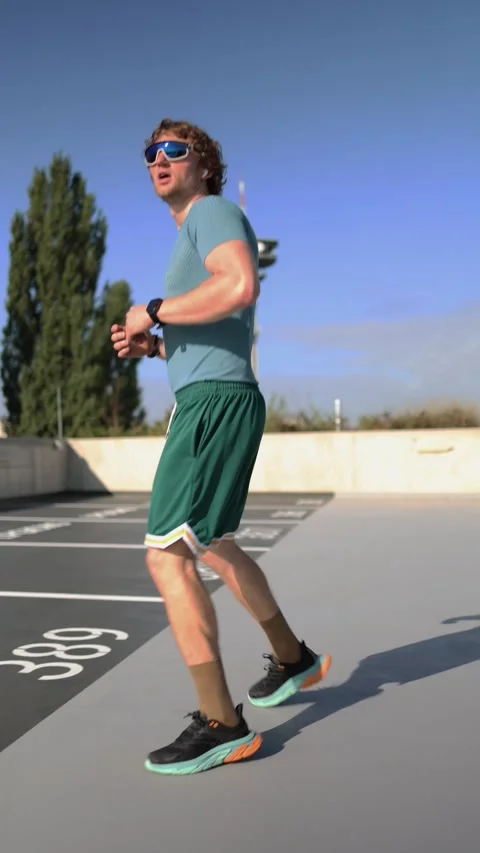 Athlete performs side jumps during warmup using urban space for fitness Stock Footage 345993767