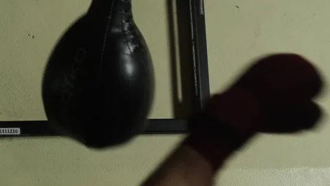 Athlete practices hitting speed bag practicing in dimly lit gym Stock Footage 306663382