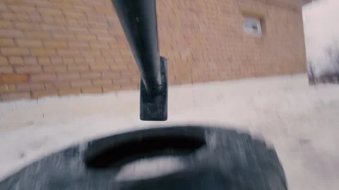 An athlete practices hitting a wheel with a heavy sledgehammer. Stock Footage 321858869