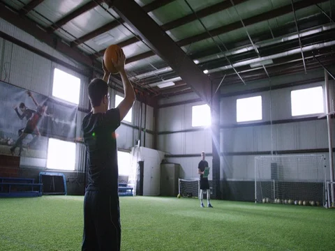 Athlete practicing to accurately throw the ball towards the goal post 動画素材 77325657