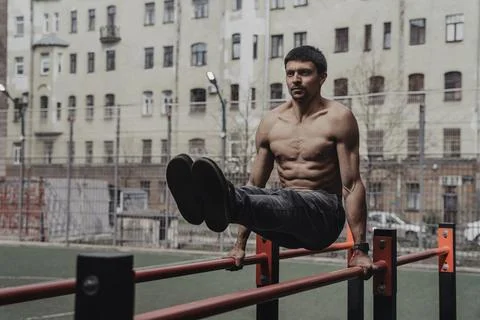 Athlete practicing calisthenics with smartwatch on his wrist. Stock Photos