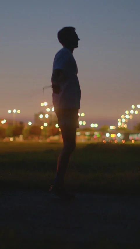 Athlete practicing controlled landings during evening in city park Видео 334119565