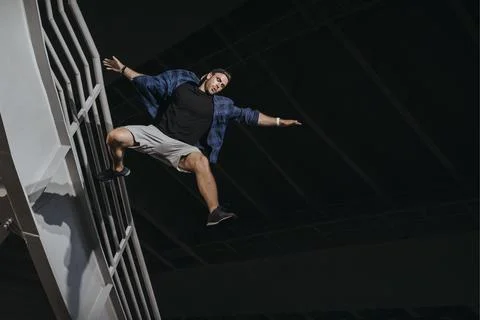 Athlete practicing freerunning doing big scary jump. Stock Photos