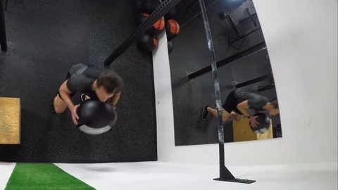 Athlete practicing wall ball shots with a med ball at the gym. Stock Footage 112650476