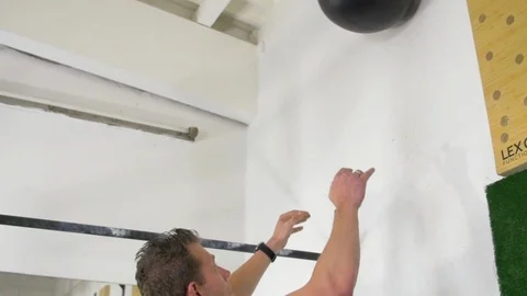 Athlete practicing wall ball shots with a med ball at the gym. Stock Footage 113422324