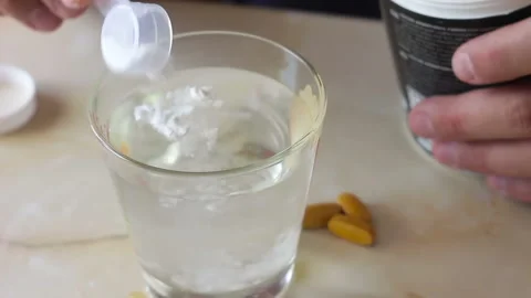 The athlete prepares a portion of creatine or amino acids for consumption 库存影片 104657237