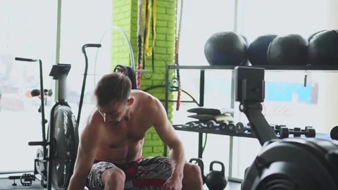 An athlete prepares for training on a rowing machine. Training and fitness Stock Footage 250178428