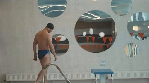 The athlete is preparing to jump into the pool and jumps Stock Footage 125572952