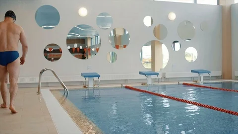 The athlete is preparing to jump into the pool and jumps Stock Footage 125572969