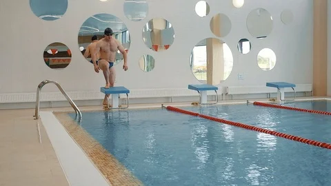 The athlete is preparing to jump into the pool and jumps Stock Footage 125573028