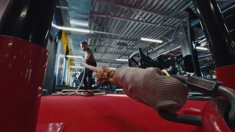 Athlete Pulling Loaded Sled By Rope Across Gym Workout Lane During Strength Stock Footage 336279728