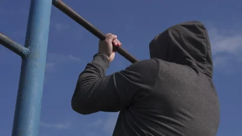 An athlete in  pulls up on a bar, calisthenics workout Stock Footage 218467875