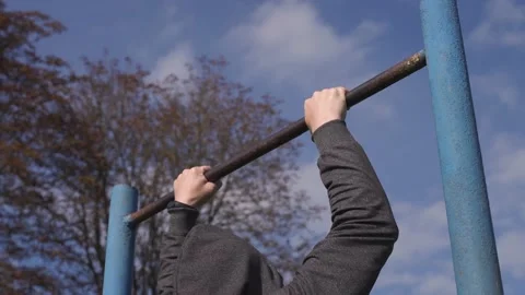 An athlete in  pulls up on a bar, calisthenics workout Stock Footage 218467888