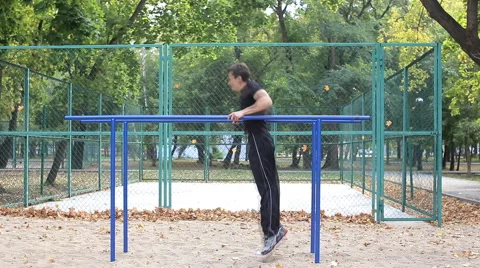 Athlete pulls on the bars in park Stock Footage 55709451