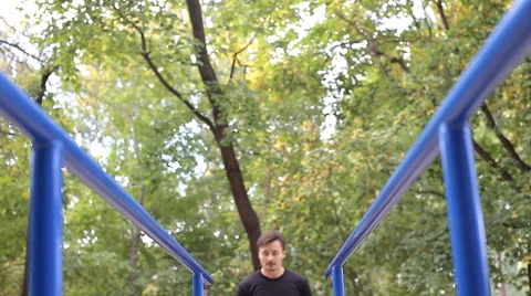 Athlete pulls on the bars in park Stock Footage 55710837