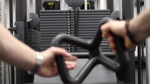 Athlete pulls cable handle during focused gym strength session Stock Footage 337346715
